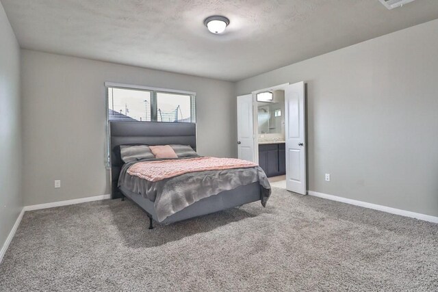 107 Meadow Lake Ct, Navasota, TX 77868 - bedroom featuring light carpet, baseboards, ensuite bathroom, and a textured ceiling