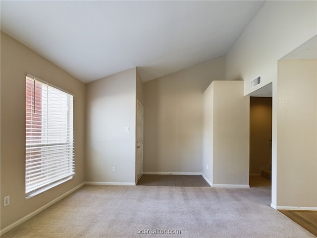 empty room featuring light carpet and lofted ceiling