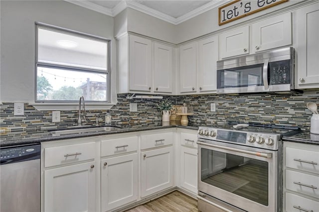 kitchen with white cabinetry, decorative backsplash, stainless steel appliances, and a sink