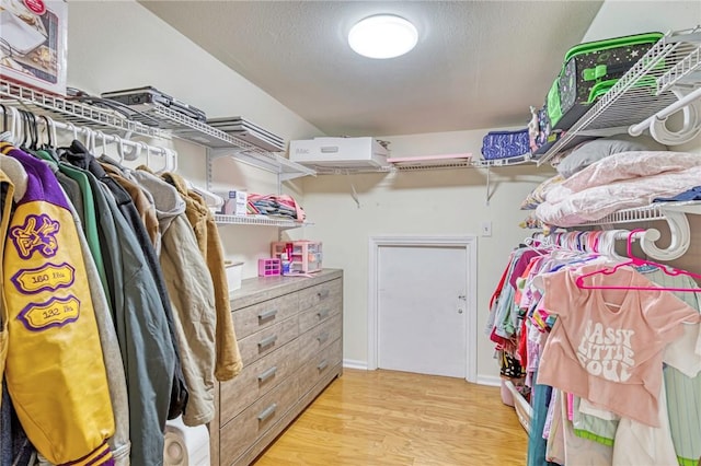 walk in closet with wood finished floors