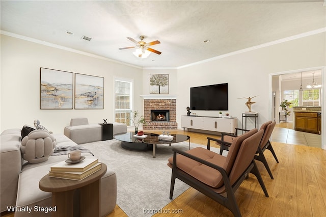 934 Dove Landing Ave, College Station, TX 77845 - living room featuring visible vents, a ceiling fan, a fireplace, and ornamental molding