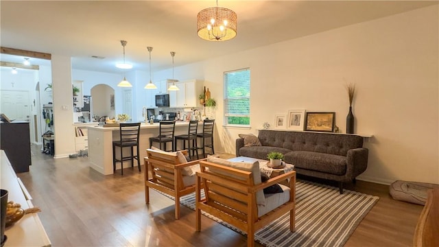 301 Pine Mist Ln, Conroe, TX 77304 - living area featuring wood finished floors, a chandelier, and arched walkways