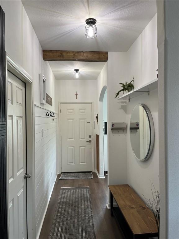 301 Pine Mist Ln, Conroe, TX 77304 - mudroom featuring beam ceiling, dark wood-style floors, and arched walkways