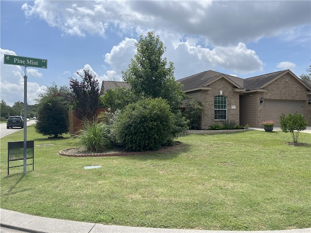 301 Pine Mist Ln, Conroe, TX 77304 - view of front of home with a garage, brick siding, and a front lawn