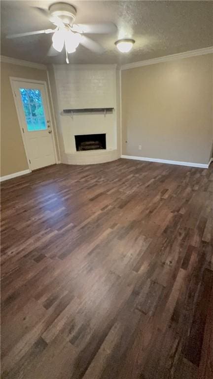 1503 Tara Ct, College Station, TX 77840 - unfurnished living room featuring crown molding, dark wood-style flooring, a fireplace, ceiling fan, and a textured ceiling