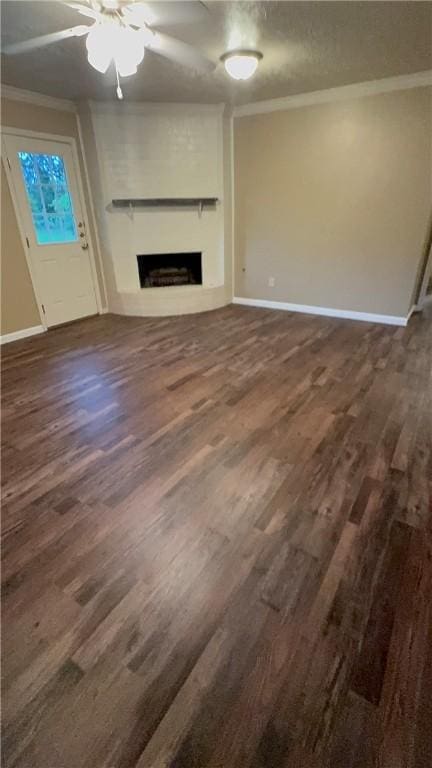 1503 Tara Ct, College Station, TX 77840 - unfurnished living room with ornamental molding, a fireplace, dark wood-style flooring, and a ceiling fan