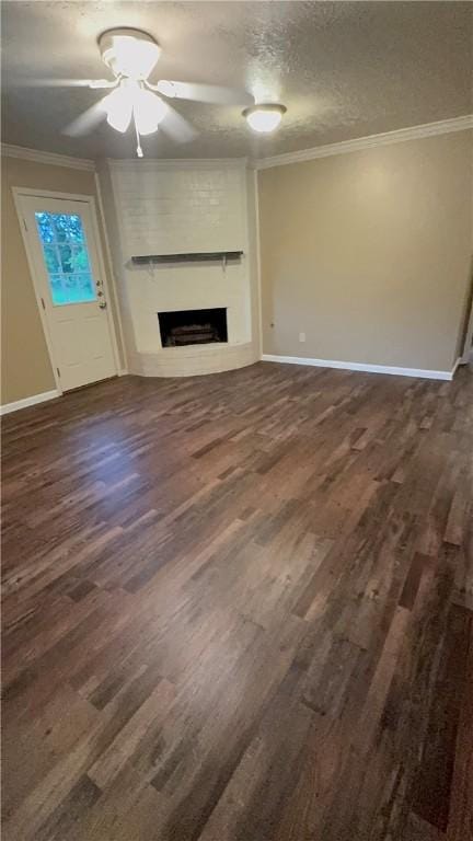 1503 Tara Ct, College Station, TX 77840 - unfurnished living room with a fireplace, crown molding, dark wood-style flooring, a ceiling fan, and a textured ceiling