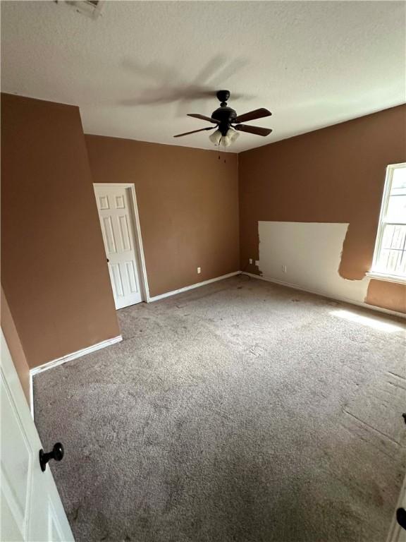 1113 W 10th St, Hearne, TX 77859 - spare room with carpet floors, ceiling fan, and a textured ceiling