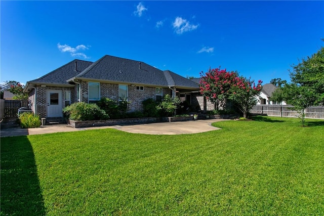 back of house with a lawn and a patio