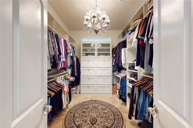 walk in closet with a chandelier