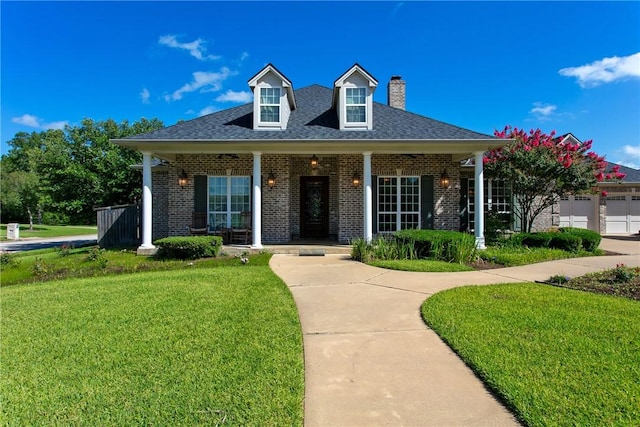 view of front of home featuring a garage, covered porch, and a front yard