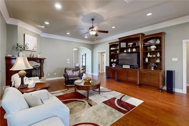 living room featuring crown molding, ceiling fan, and wood-type flooring