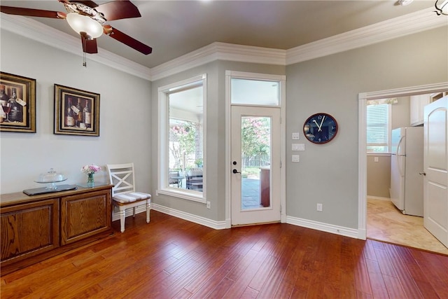 doorway with crown molding, hardwood / wood-style flooring, and ceiling fan