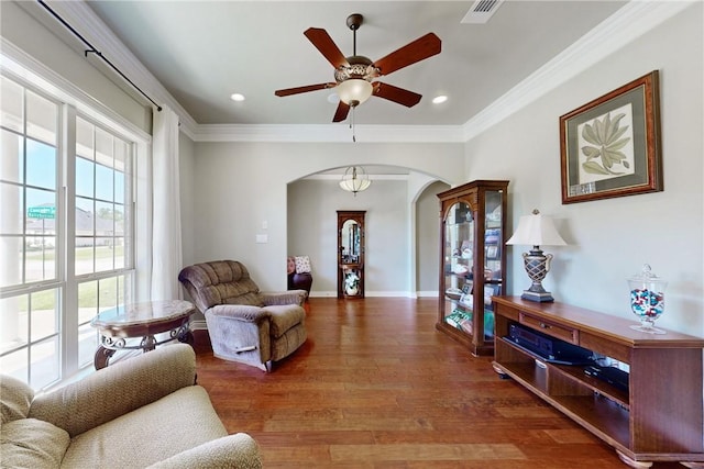 living room with ornamental molding, ceiling fan, and dark hardwood / wood-style flooring