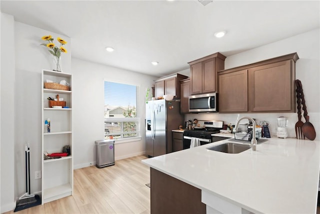 1121 Amistad Loop, College Station, TX 77845 - kitchen with appliances with stainless steel finishes, light countertops, a peninsula, light wood-type flooring, and recessed lighting
