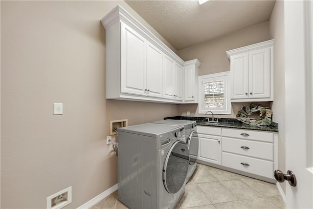 laundry room featuring cabinets, light tile patterned floors, a textured ceiling, and sink