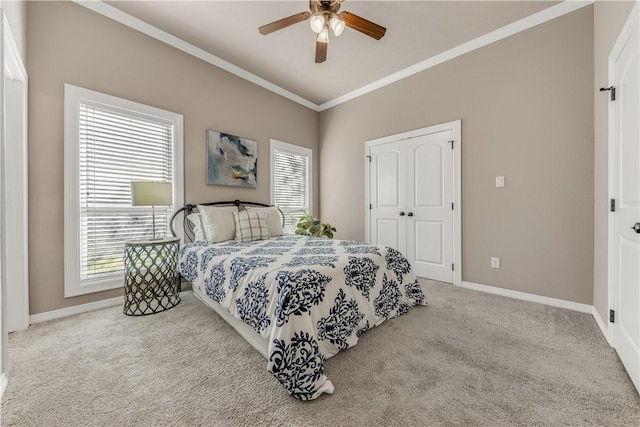 bedroom with crown molding, ceiling fan, a closet, and light colored carpet