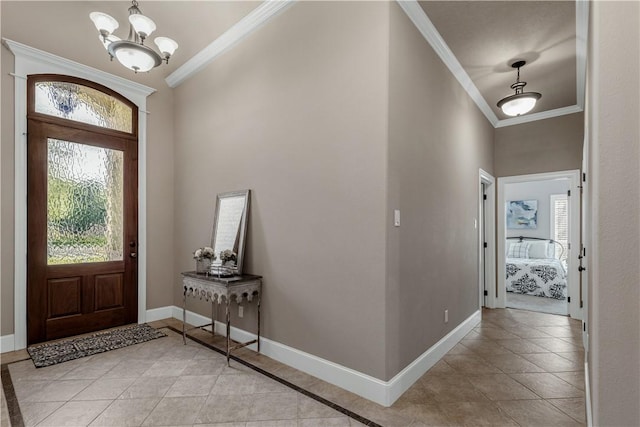 tiled entrance foyer with plenty of natural light, ornamental molding, and an inviting chandelier