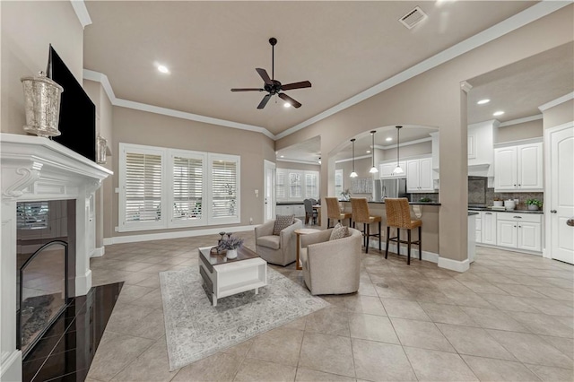 living room featuring light tile patterned floors, ceiling fan, and crown molding