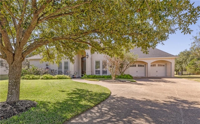 view of front of property with a front yard and a garage