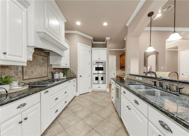 kitchen featuring white cabinets, decorative light fixtures, sink, and appliances with stainless steel finishes