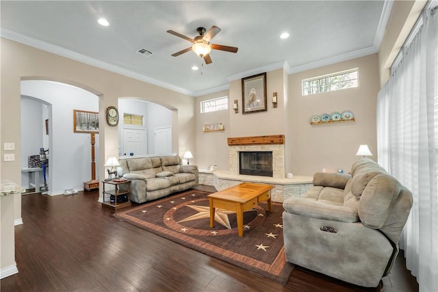 living room featuring ornamental molding, ceiling fan, a fireplace, and dark hardwood / wood-style flooring