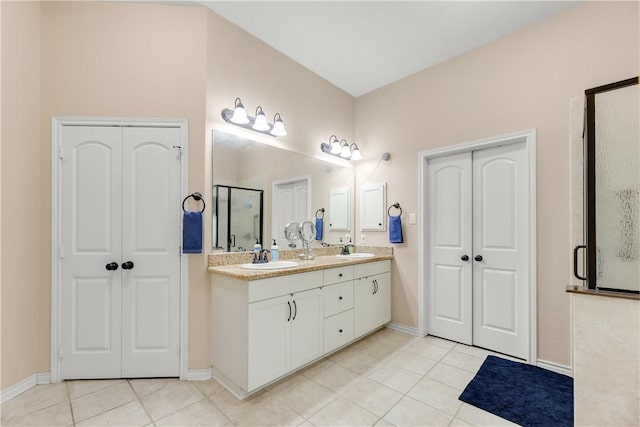 bathroom with tile patterned flooring, an enclosed shower, and vanity