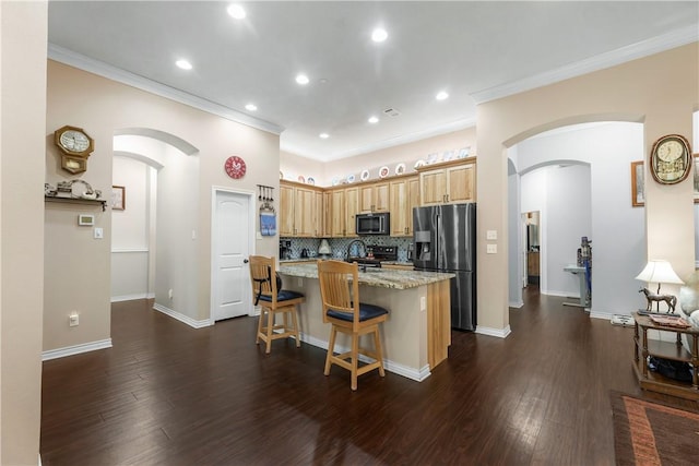 kitchen with a breakfast bar, light stone counters, black appliances, an island with sink, and dark hardwood / wood-style flooring