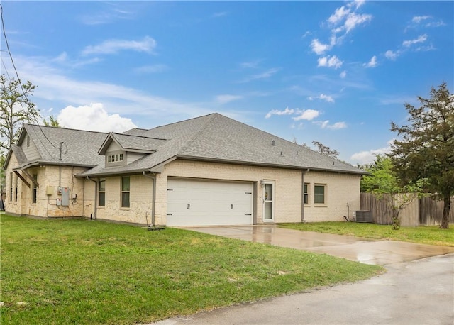 view of front of home with a garage, central AC unit, and a front lawn