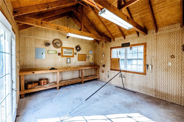 miscellaneous room with concrete floors, electric panel, an AC wall unit, and vaulted ceiling with beams