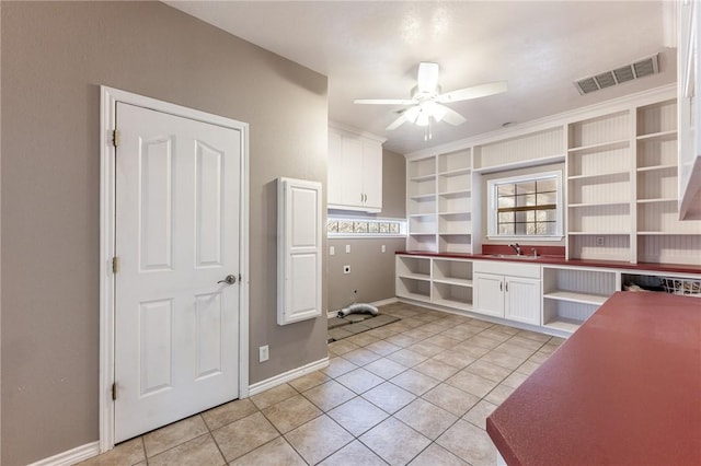 kitchen featuring ceiling fan, light tile patterned floors, sink, and white cabinetry