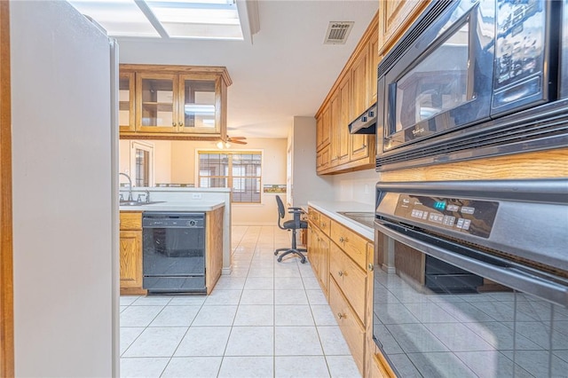 kitchen with light tile patterned floors, sink, and black appliances