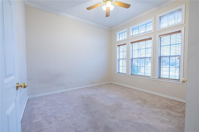 empty room with ceiling fan, crown molding, and light carpet