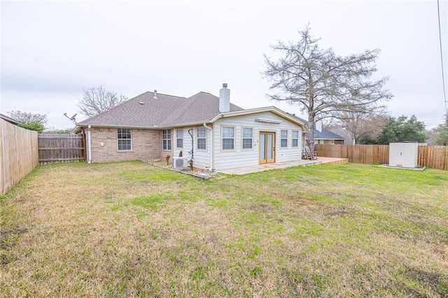 rear view of property with a storage unit, ac unit, and a yard