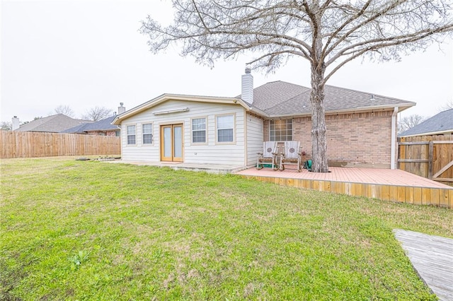 rear view of house with a deck and a lawn