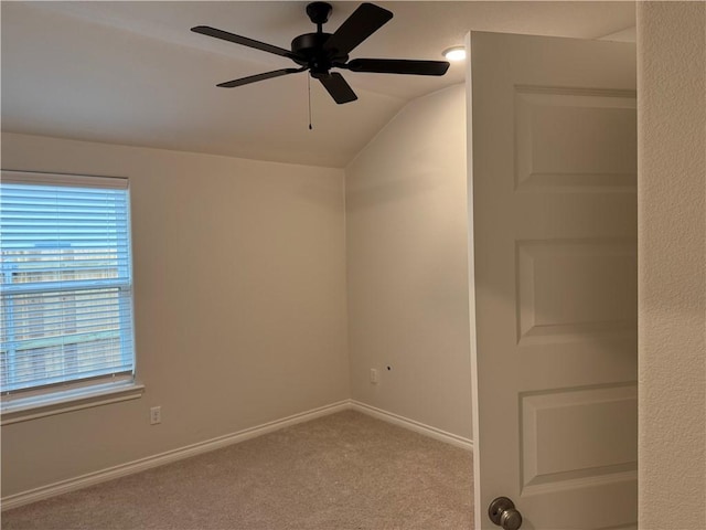 unfurnished room with vaulted ceiling, light colored carpet, ceiling fan, and plenty of natural light