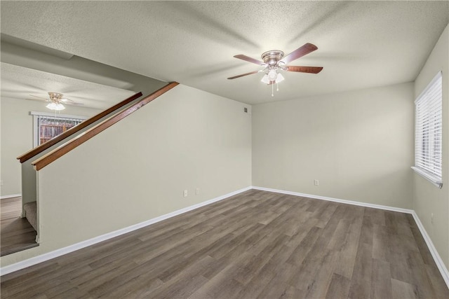 spare room with ceiling fan, dark hardwood / wood-style flooring, and a textured ceiling