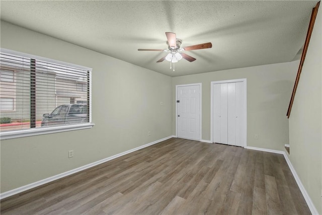 unfurnished bedroom with a textured ceiling, light hardwood / wood-style flooring, and ceiling fan