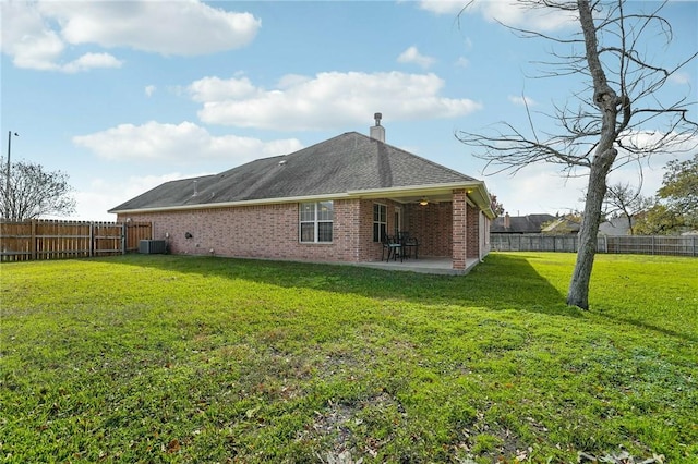 back of house with central AC, a yard, and a patio