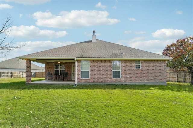 rear view of property featuring a lawn, ceiling fan, and a patio area