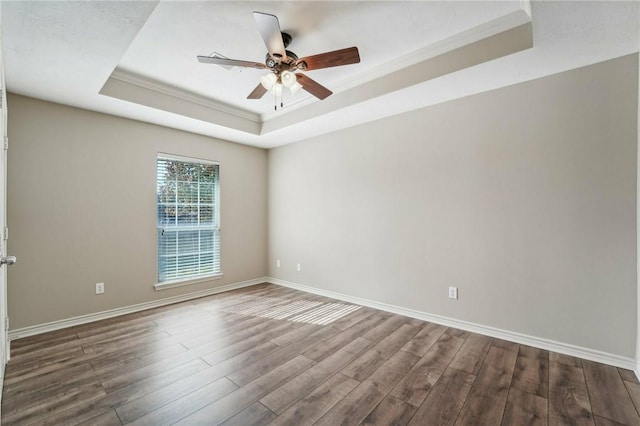 spare room with a tray ceiling, crown molding, ceiling fan, and wood-type flooring