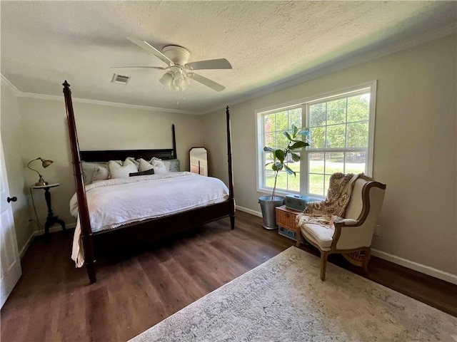 bedroom with a textured ceiling, ceiling fan, dark hardwood / wood-style floors, and ornamental molding