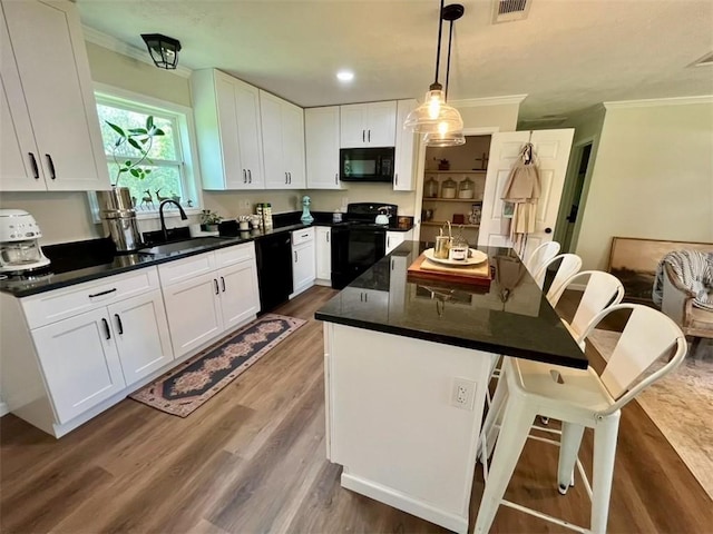 kitchen featuring a kitchen island, dark hardwood / wood-style flooring, decorative light fixtures, white cabinets, and black appliances