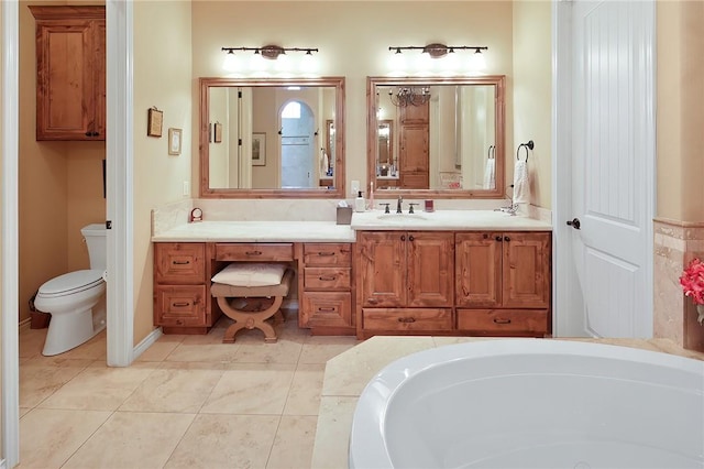 bathroom featuring vanity, tile patterned floors, a tub, and toilet