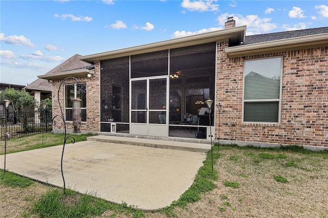 rear view of property with a patio area, a sunroom, and a lawn