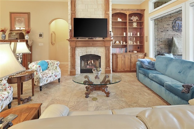 living room featuring crown molding and a fireplace