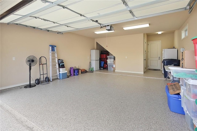 garage featuring a garage door opener and white fridge