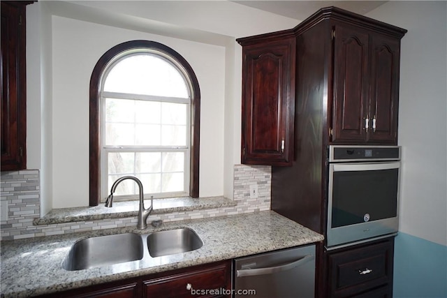 kitchen with backsplash, a wealth of natural light, sink, and stainless steel appliances