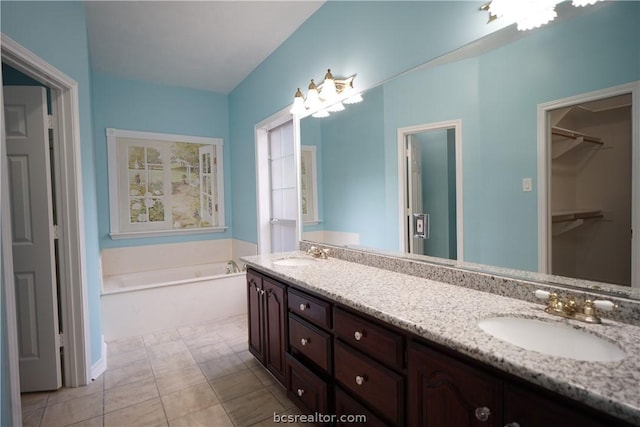 bathroom featuring tile patterned flooring, vanity, and a bathtub