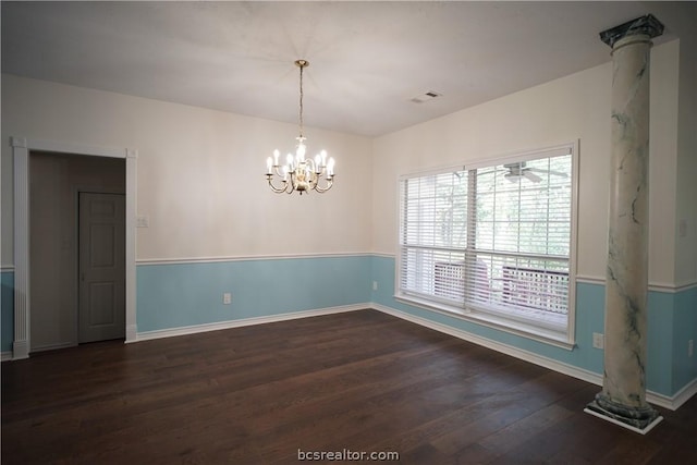 spare room featuring dark hardwood / wood-style floors and an inviting chandelier